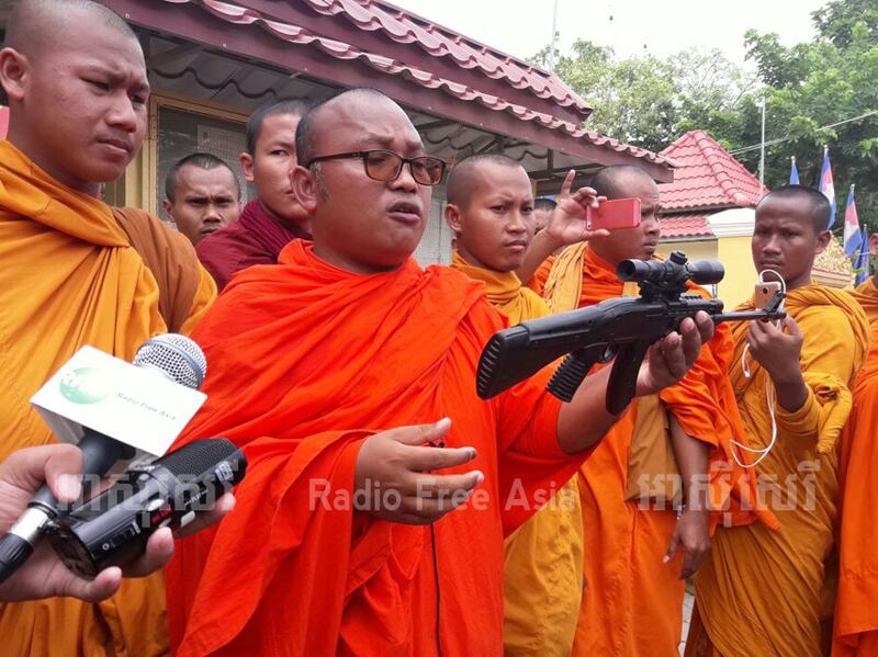 ស្ថាបនិក​បណ្ដាញ​ព្រះសង្ឃ​ឯករាជ្យ​ដើម្បី​យុត្តិធម៌​សង្គម ព្រះតេជព្រះគុណ ប៊ុត ប៊ុនតិញ ធ្វើ​សន្និសីទ​កាសែត​បង្ហាញ​កាំភ្លើង​ជ័រ ព្រះតេជព្រះគុណ ហន សុផាន្នី យក​មក​លេង​សើច នា​មុខ​សាលាដំបូង​ខេត្ត​បាត់ដំបង នៅ​ថ្ងៃ​ទី​២២ ខែ​មិថុនា ឆ្នាំ​២០១៧។ RFA/Hum Chamroeun