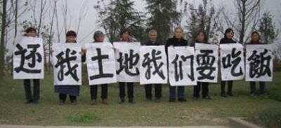 图片:四川省成都市双流区兴隆镇保水村村民代表,高举横幅抗议他们的土地被强占。(志愿者提供)