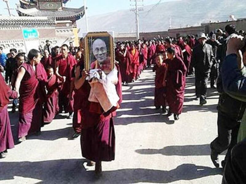 僧人替死者舉行祈福超度法會，並手持達賴喇嘛照片進行儀式。（照片來自西藏作家唯色推特）