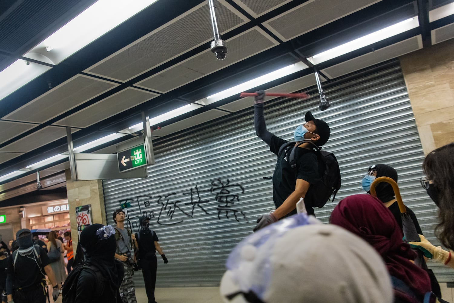 A protestor  vandalizes a surveillance camera in a shopping mall in Shatin on October 13, 2019 in Hong Kong.