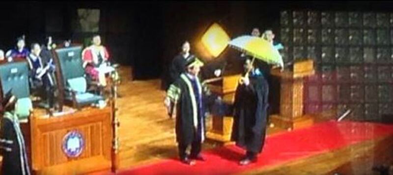 2014年11月17日，浸會大學傳理學院舉行畢業禮時，有畢業生撐黃傘上台接受畢業證書，校長陳新滋未有即場頒授。（現場學生提供）