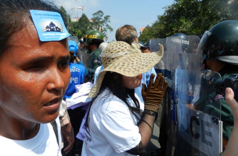 ក្រុម​ពលរដ្ឋ​មាន​ជម្លោះ​ដីធ្លី អង្វរ​ក្រុម​សមត្ថកិច្ច​ចម្រុះ​ដែល​រារាំង​ពួក​គាត់​ហែ​ក្បួន​ដាក់​ញត្តិ នា​មុខ​សាលា​រាជធានី​ភ្នំពេញ នៅ​ព្រឹក​ថ្ងៃ​ទី១០ ខែ​តុលា ឆ្នាំ​២០១៣។