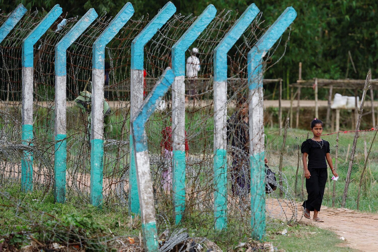 A Rohingya refugee walks past a camp border fence in Cox’s Bazar, Bangladesh, Sept. 28, 2024. (Reuters)