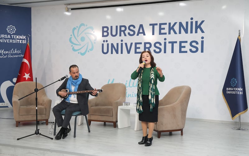 مەرھۇم ئەيسا يۈسۈپ ئالىپتېكىن ۋاپاتىنىڭ 29-يىلى مۇناسىۋىتى بىلەن بۇرسا شەھىرىدىكى تېخنىكا ئۇنىۋېرسىتېتىنىڭ ساھىبخانىلىقىدا ئۆتكۈزۈلگەن دوكلات بېرىش يىغىنىدا مۇزىكا پىروفېسسورى ئەردەم ئۆزدەمىر ئەپەندىنىڭ راۋاب چېلىشى بىلەن رەھىمە مەھمۇد خانىم ناخشا ئورۇنلىماقتا. 2024-يىلى 17-دېكابىر، تۈركىيە.