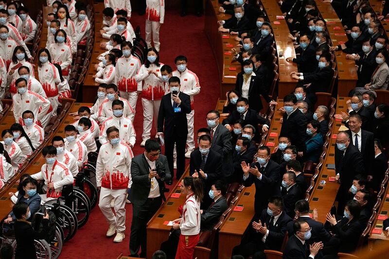 2022年4月8日，在人民大会堂举行的北京冬奥会和残奥会楷模表彰仪式上，奥运金牌得主谷爱凌（居中）抵达现场，与会者鼓掌。（美联社）