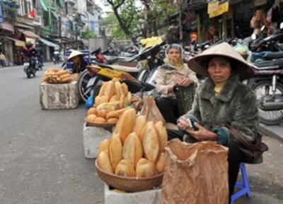 Giá cả tăng làm đôi vai người nghèo càng thêm nặng gánh. AFP photo
