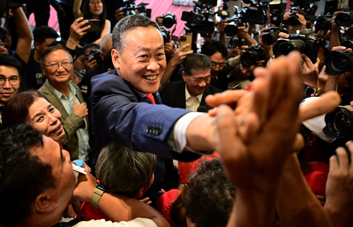 In happier times, Srettha Thavisin (center) greets supporters at Pheu Thai Party headquarters after MPs elected him as prime minister, Aug. 22, 2023. (Manan Vatsyayana/AFP)