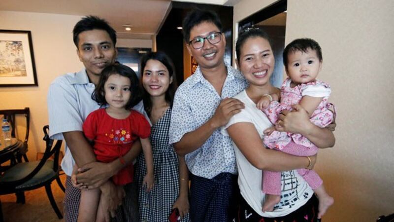 Reuters Myanmar reporter Kyaw Soe Oo (L) poses with wife Chit Su Win (3rd from L) and their daughter, along with Reuters reporter Wa Lone (3rd from R) and his wife Pan Ei Mon (2nd from R) and their daughter, after being freed from Insein Prison in Yangon under a presidential amnesty, May 7, 2019.