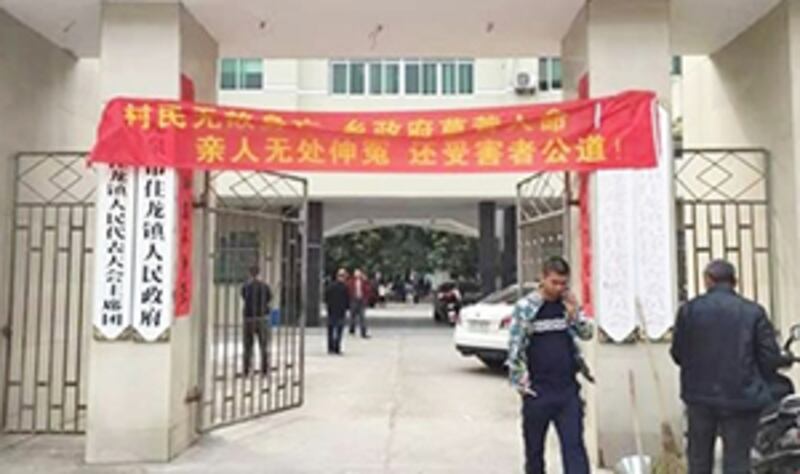 2015年4月27日，浙江龍泉巿住龍鎮村民吳忠偉死亡後一日，家屬把抗議額掛在鎮政府門外申冤。（照片由維權人士提供）