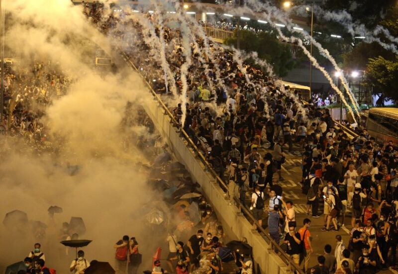 图片:香港警方向抗议人群发射催泪弹。(法新社)