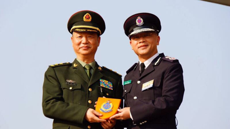 醫療輔助隊總參事許偉光(右),送贈紀念品予駐港解放軍代表。(現場人士攝)