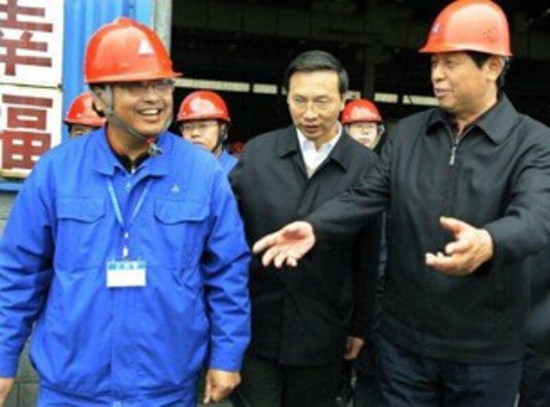 图片：前中共贵州省委书记栗战书（右）于2010年访问贵阳的一个国有工厂。（法新社）