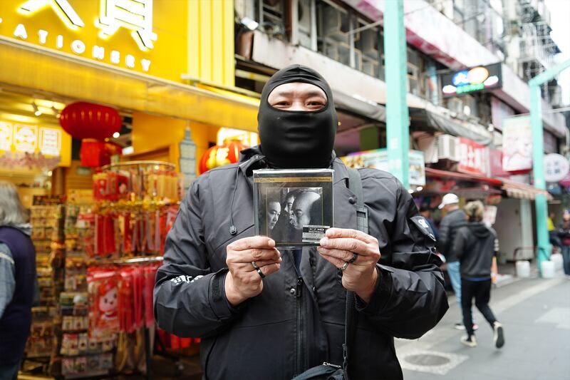 反對香港《禁蒙面法》的台灣人陳先生蒙面到場，他帶同由潘源良填詞的粵語大碟索取簽民。（淳音攝）