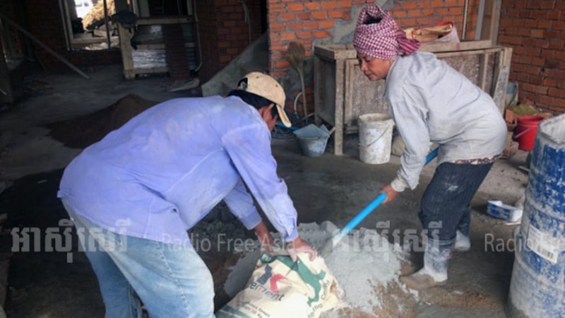 លោកស្រី កែវ ណាគ្រី (ស្ដាំ) កំពុងលាយស៊ីម៉ងត៍ នាសំណង់បុរីមួយកន្លែងនៅរាជធានីភ្នំពេញ កាលពីថ្ងៃទី១ ខែវិច្ឆិកា ឆ្នាំ២០១៧។