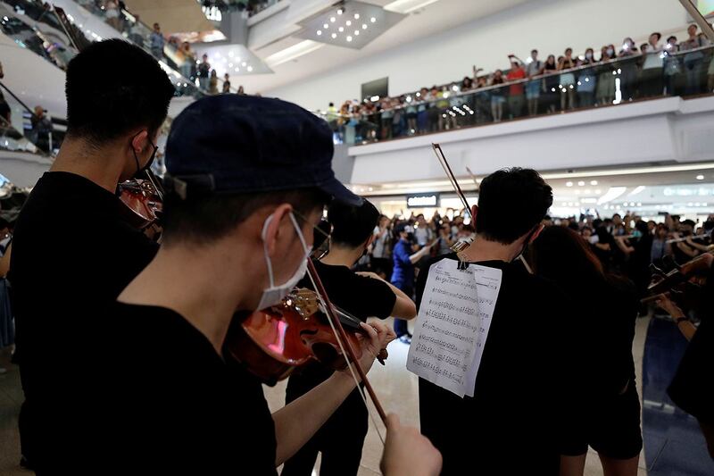 2019年9月18日，一群音乐表演者在香港九龙塘一间购物商场演奏《愿荣光归香港》。（路透社）