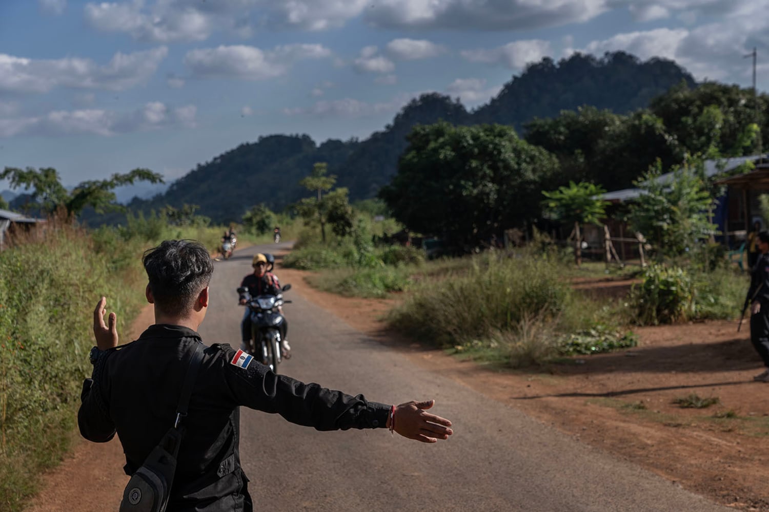 An officer from KSP Station 8 motions for a motorcyclist to stop at a checkpoint in southern Shan state, Myanmar, Nov. 4, 2024.