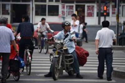 Người dân Trung Quốc trên đường phố ở Bắc Kinh vào ngày 24 tháng 6 năm 2013. AFP photo