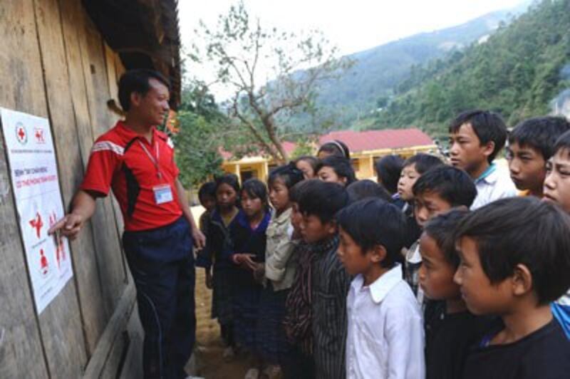 Một giáo viên đang giải thích về bệnh tay, chân, miệng cho học sinh dân tộc Hmong ở Yên Bái năm 2012. 