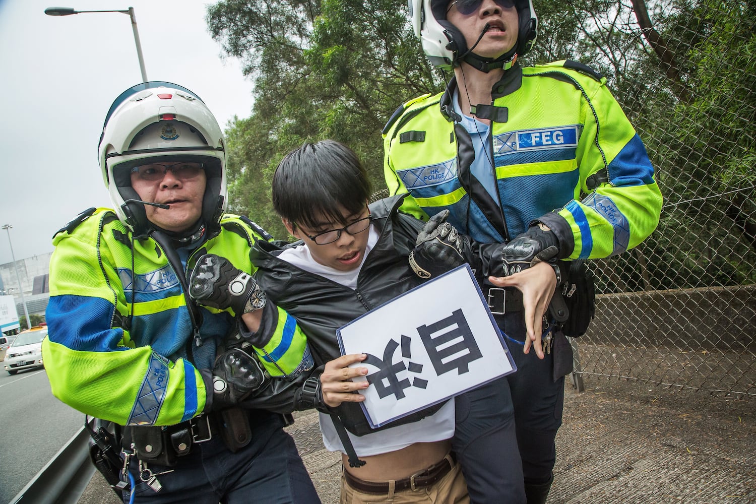 In this photo provided by Demosisto, Joshua Wong, secretary general of the political party Demosisto, is taken away by traffic police during an attempt to intercept the motorcade of top Chinese official Zhang Dejiang on May 19, 2016 in Hong Kong. (Getty Images)