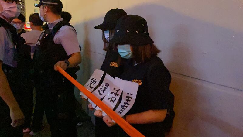 有市民舉起標語,上書「有些人死了,但他們還活著」。(李智智 攝)