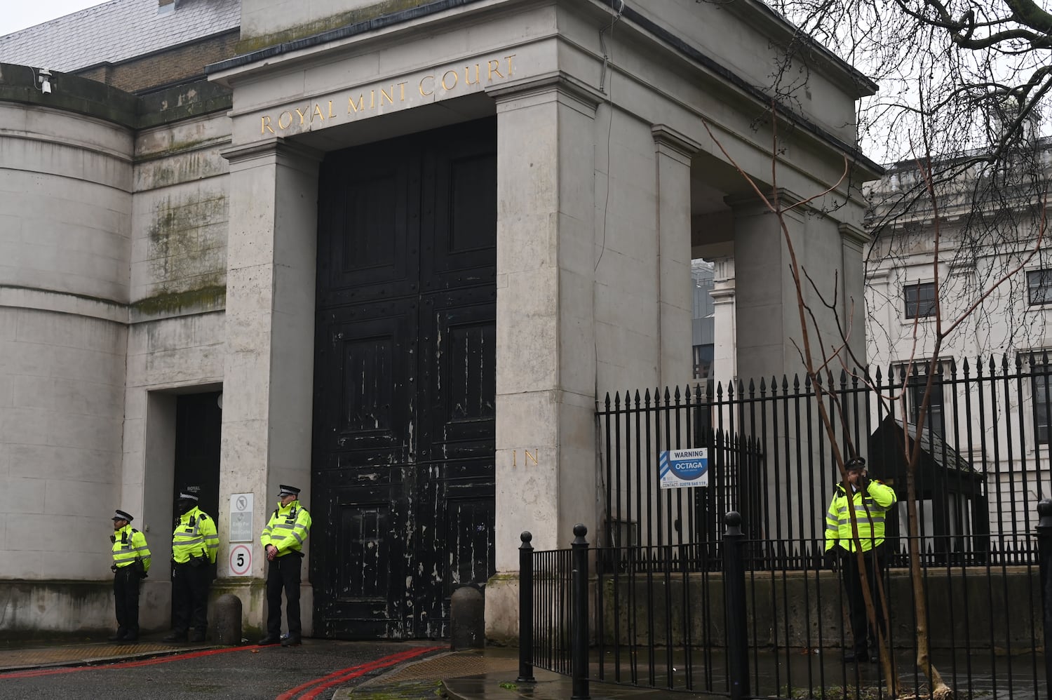 Police stand outside Royal Mint Court, the controversial site of China's proposed new 