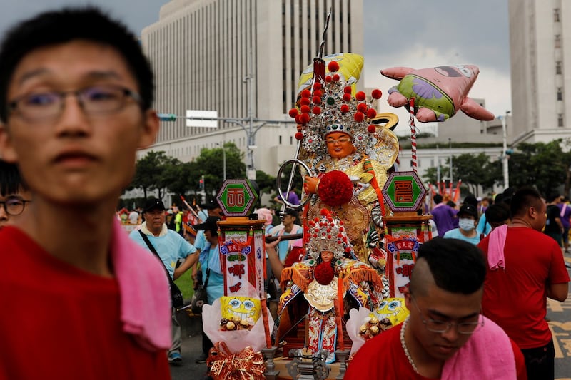 台北,信徒抬着道教女神妈祖和哪咤的雕像参加宗教游行,抗议政府为改善空气品质而减少烧纸的政策。(路透社)