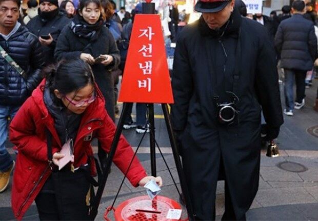 서울 중구 명동 거리를 찾은 한 어린이가 구세군 자선냄비에 성금을 넣고 있다.