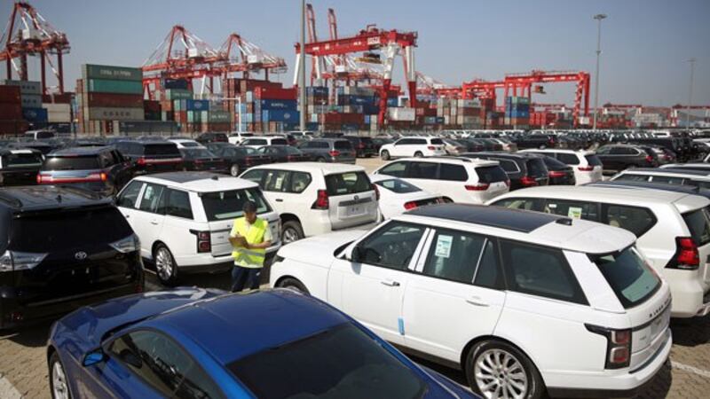 A worker inspects imported cars at a port in Qingdao, eastern China's Shandong province, May 23, 2018. 