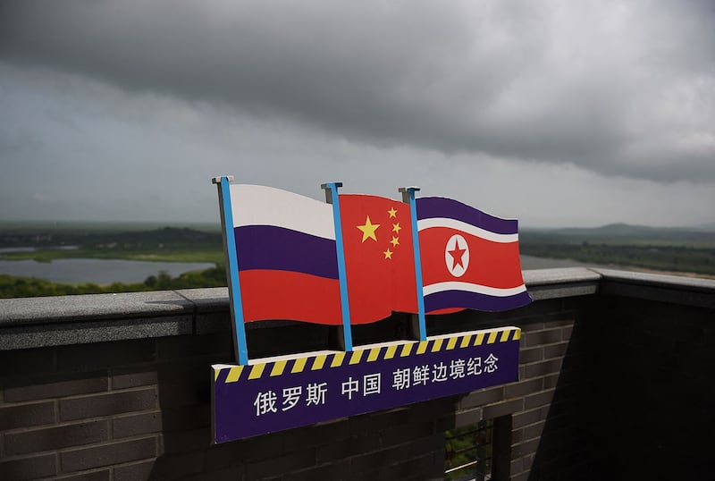 资料图片:中国吉林省珲春市三国交界处的龙虎阁观景台上的俄罗斯、中国和朝鲜国旗。(法新社)