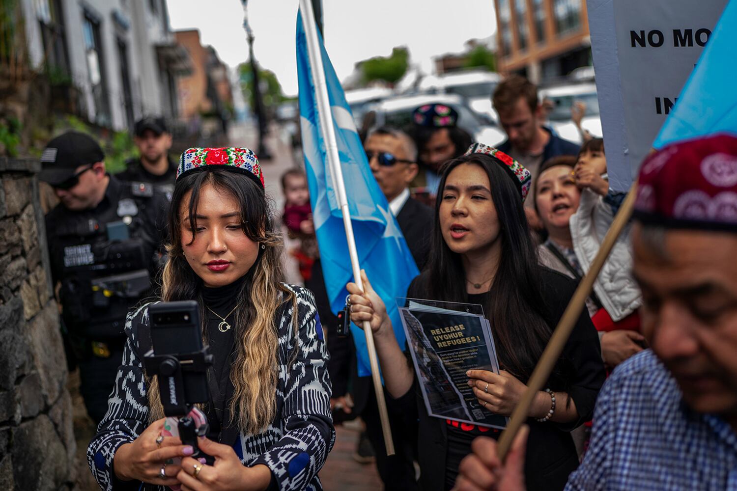 Shahrezad Ghayrat, a journalist with RFA's Uyghur language service, left, live-streams a Uyghur demonstration outside the Thai embassy in Washington, May 5, 2023. 