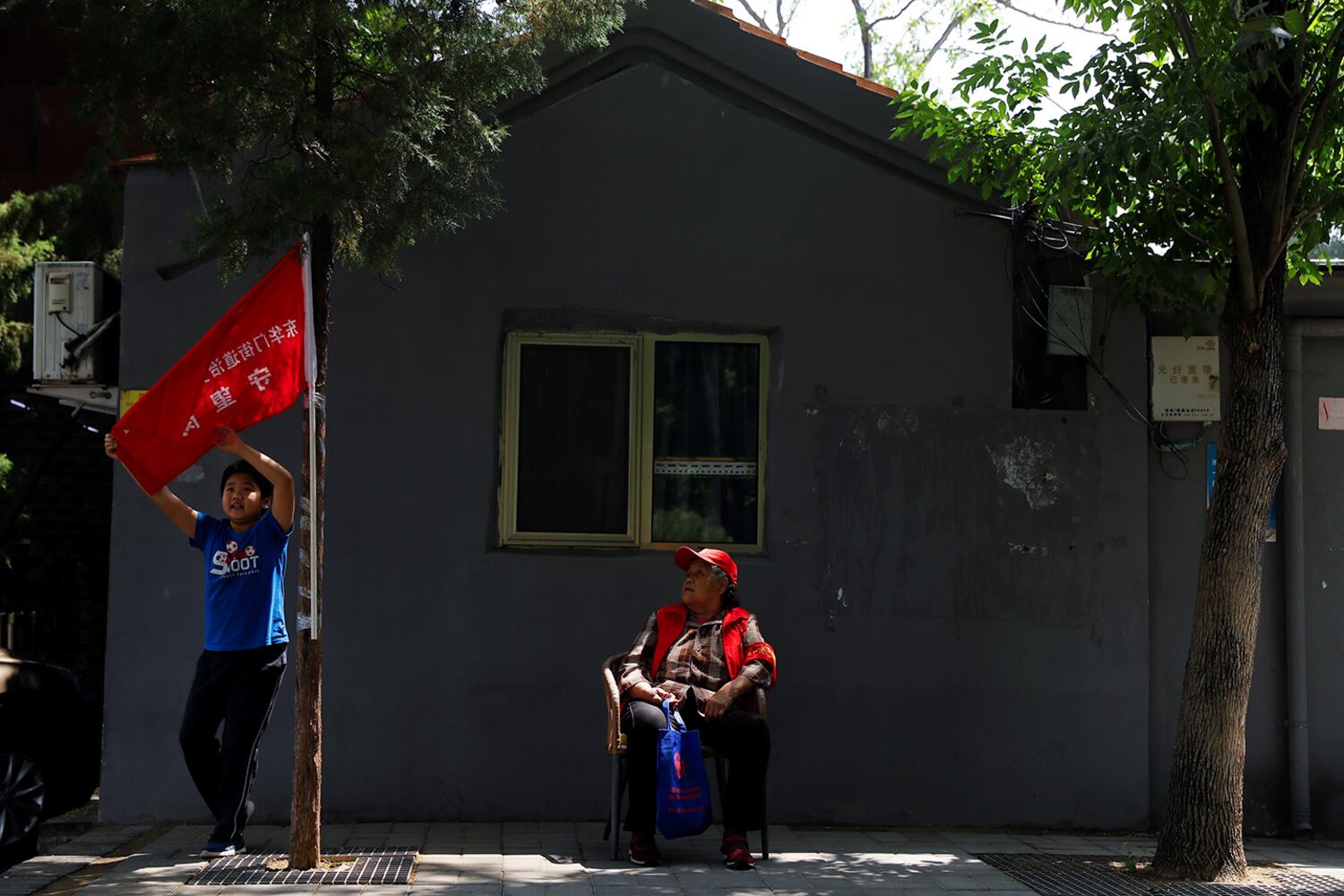 A member of a neighborhood party committee keeps watch along a street in Beijing, May 22, 2020.