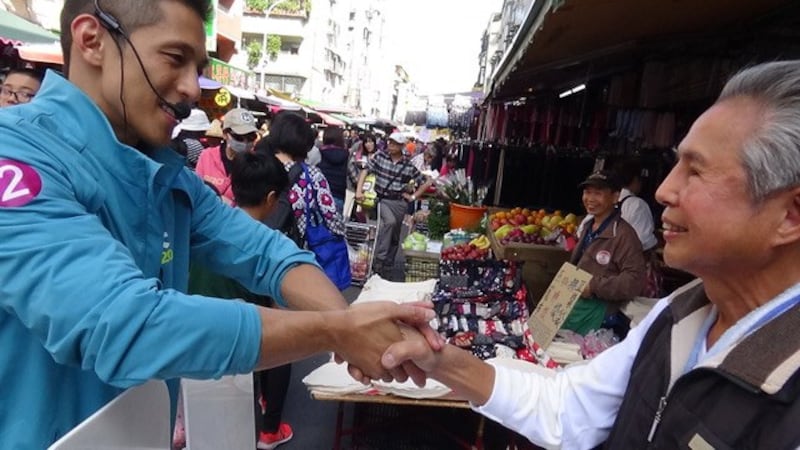 民进党立委候选人吴怡农市场拜票，男女老少通吃。(记者 夏小华摄)