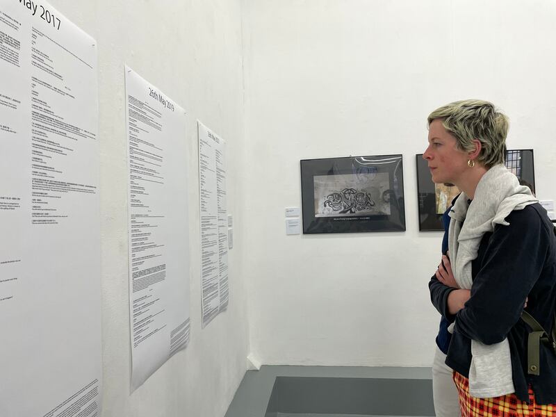 當地人Rachel逐一仔細欣賞11位藝術家的作品，她說這次展覽讓她可以在新聞冷冰冰的資訊以外，感同身受地理解香港人是如何抵抗不公義。（呂熙 攝）