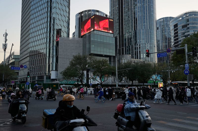 2023年11月18日，北京零售区附近，屏幕上显示着中国国旗。（美联社图片）