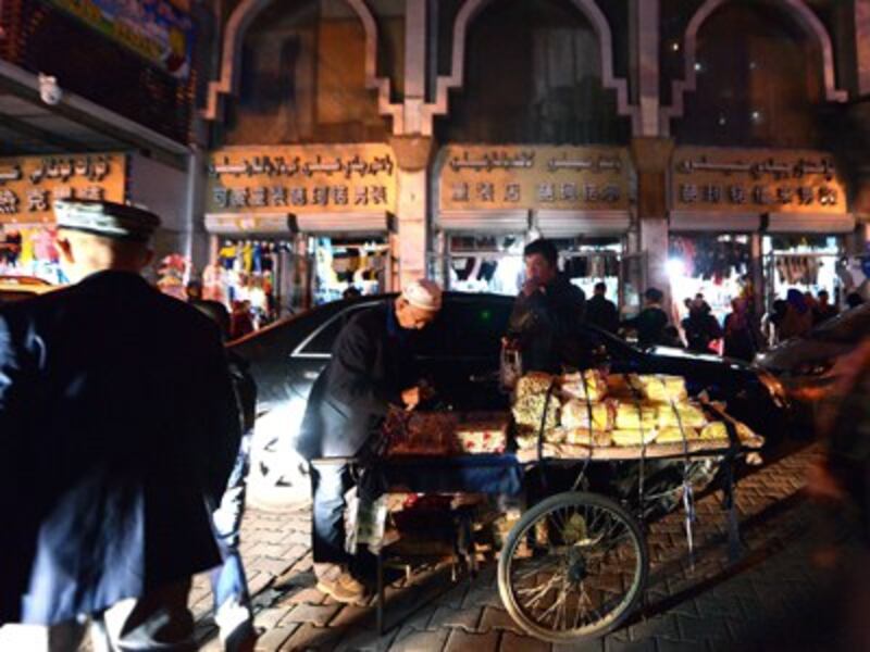 An elderly Uyghur vendor sells his wares near the Grand Bazaar in Urumqi, Sept. 17, 2014.