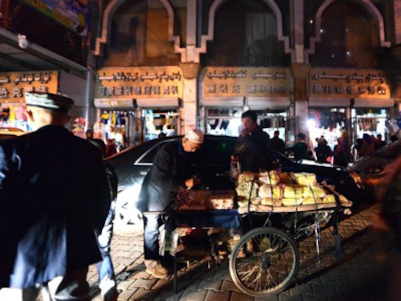 An elderly Uyghur vendor sells his wares near the Grand Bazaar in Urumqi, Sept. 17, 2014.