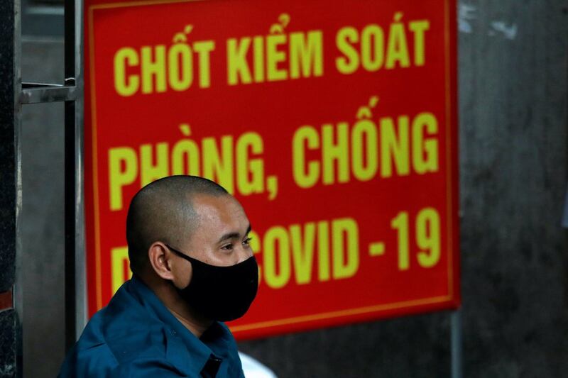Hình minh hoạ. Một nhân viên dân phòng đeo khẩu trang đứng canh bên ngoài một thôn bị phong toả ở Hà Nội vì có bệnh nhân nhiễm COVID-19 hôm 4/8/2020