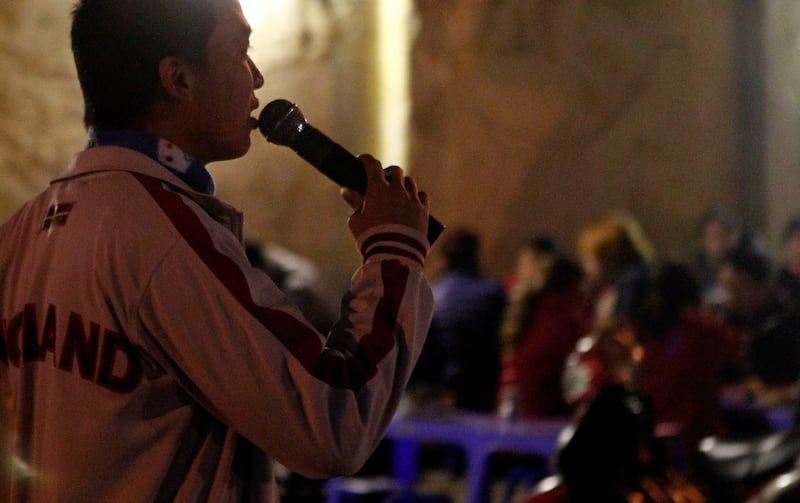 Một người đàn ông hát karaoke trước một quán ăn ven đường. Reuters.