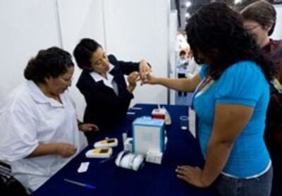 Các y tá lấy mẫu máu để xét nghiệm lượng cholesterol, ảnh chụp ở Mexico trước đây. AFP PHOTO.