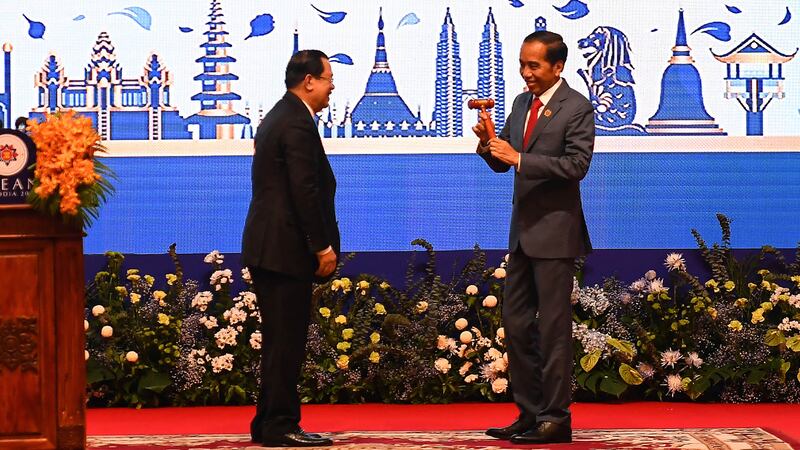 Hun Sen, left, hands over the gavel to Indonesian President Joko Widodo during a transfer of ASEAN Chairmanship during the closing ceremonies of the 40th and 41st ASEAN Summit in Phnom Penh, Cambodia, Sunday, Nov. 13, 2022 by AFP-4.jpg