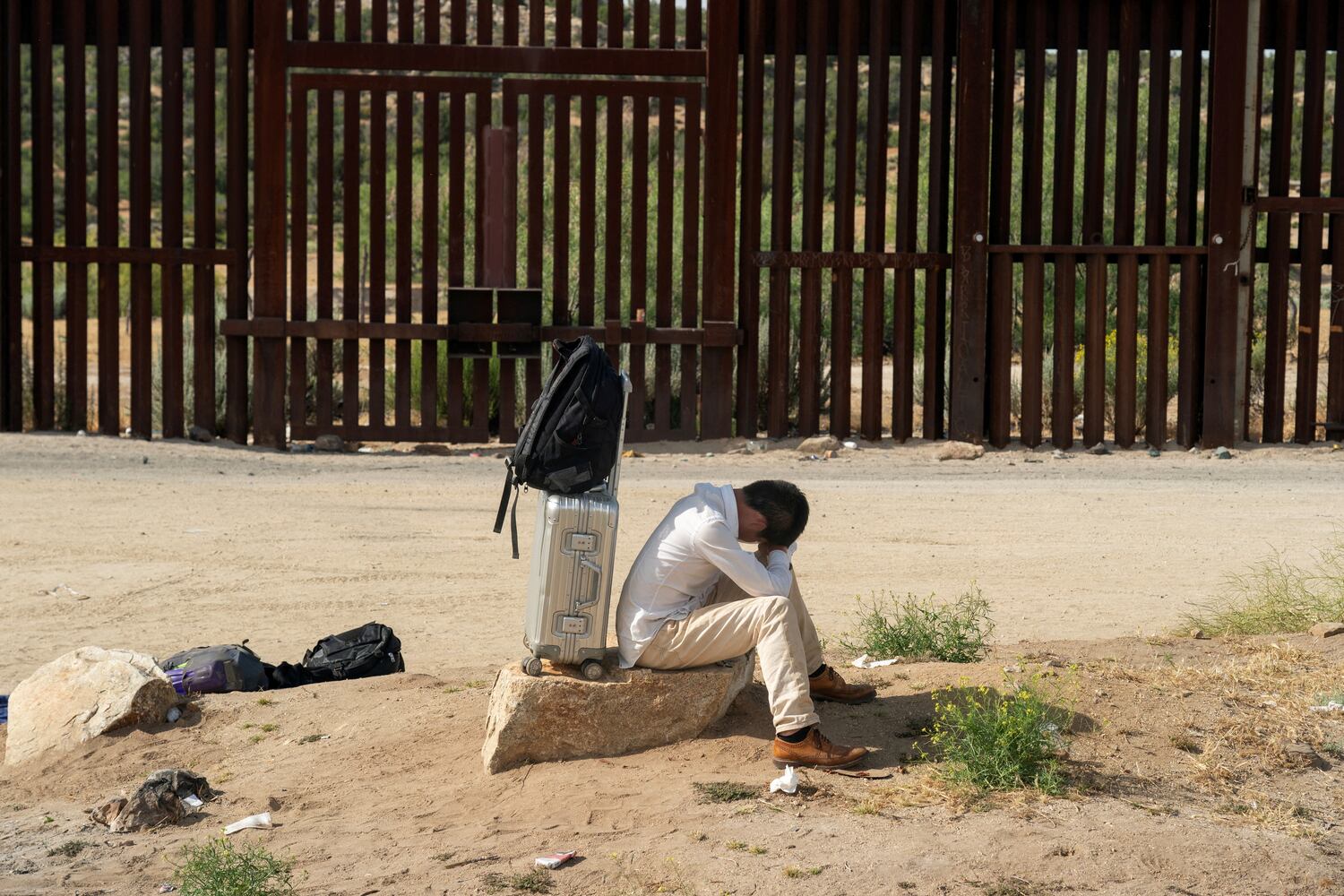 An asylum-seeking migrant from China rests while waiting to be transported by the U.S. Border Patrol after crossing the border from Mexico into the U.S. in Jacumba Hot Springs, California, June 4, 2024.