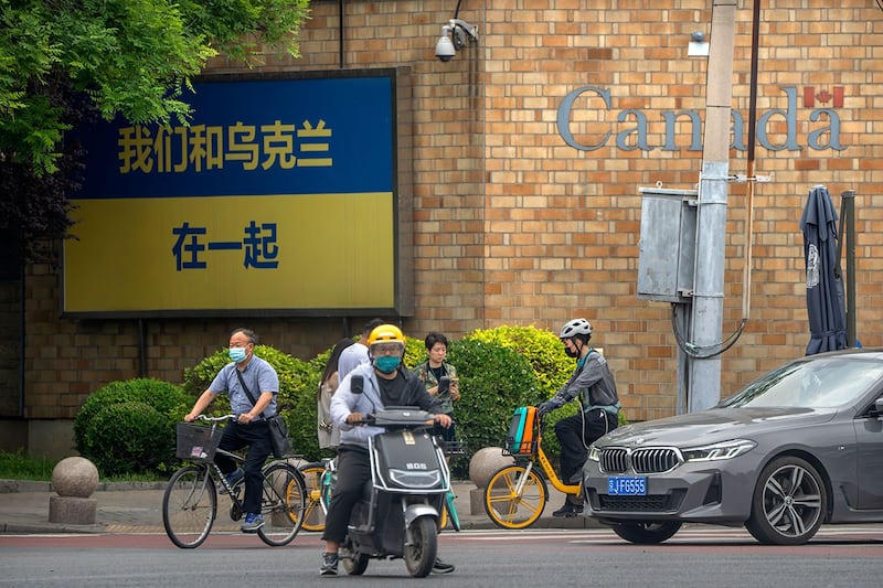 2023年5月17 日,加拿大驻北京大使馆外墙上一面巨大的乌克兰国旗,上面用汉字写着“我们与乌克兰站在一起”的口号。(美联社)