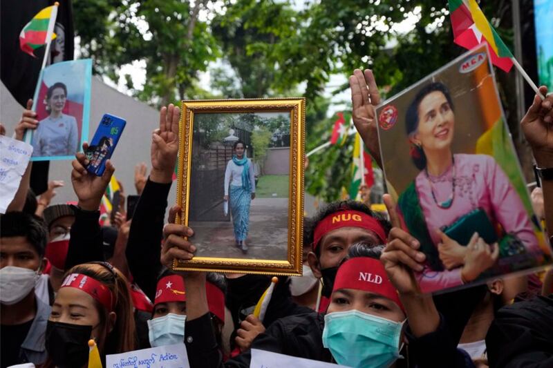 Myanmar nationals living in Thailand hold pictures of deposed Myanmar leader Aung San Suu Kyi as they protest outside Myanmar's embassy in Bangkok, July 26, 2022. Credit: Sakchai Lalit/AP