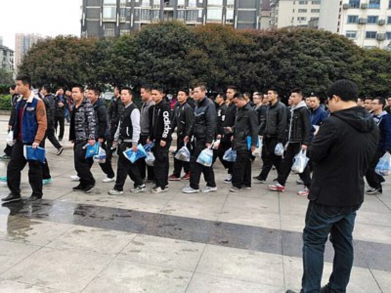 Chinese soccer 'fans,' who may be undercover police officers, carry identical goodie bags before a match between China and South Korea in Changsha, central China's Hunan province, March 22, 2017.