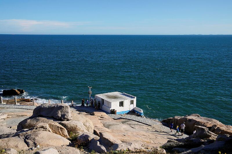 2022年8月5日，中國福建省平潭島68海里風景區，是中國大陸離台灣島最近的地點之一，人們俯瞰台灣海峽。（路透社）
