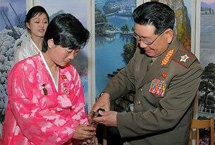 영웅메달을 가슴에 단 여성 노동자에게 술을 따라주는 황병서 총정치국장의 모습.