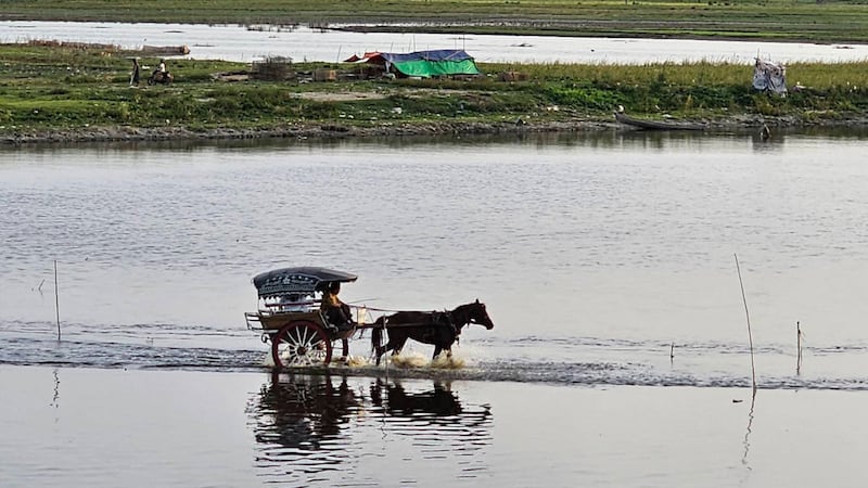 မန္တလေးမြို့၊ အမရပူရမြို့နယ်၊ တောင်သမန်အင်းတွင် မောင်းနှင်နေသည့် မြန်မာ့ရိုးရာမြင်းလှည်းတစ်စီးကို ၂၀၂၃ ခုနှစ်၊ ဇွန်လ ၁၇ ရက်နေ့က တွေ့ရစဉ်။ (Photo: RFA)