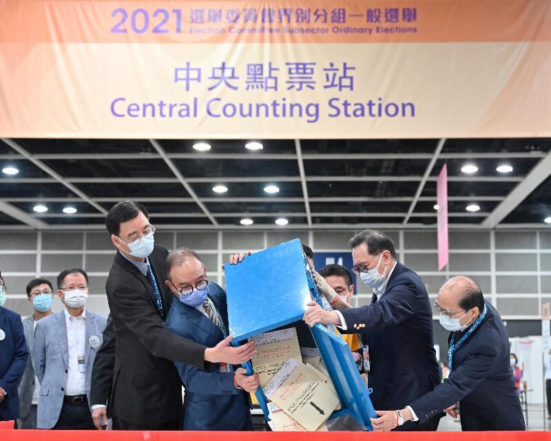 選舉管理委員會主席馮驊(右二)和政制及內地事務局局長曾國衞於中央點票站倒出票箱中的選票(香港政府新聞網圖片)