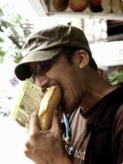 Một người nước ngoài ăn bánh mì tại Sài Gòn. Photo courtesy of oishiieatsblog.