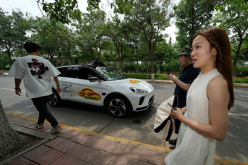 2022年6月14日,工人准备在北京乘坐百度公司开发的自动驾驶出租车。(美联社)